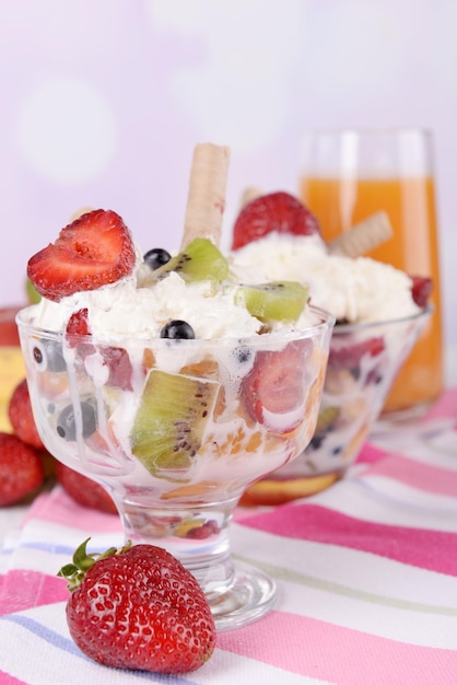 Ensalada de frutas frescas con helado en tazones y jugo sobre fondo brillante