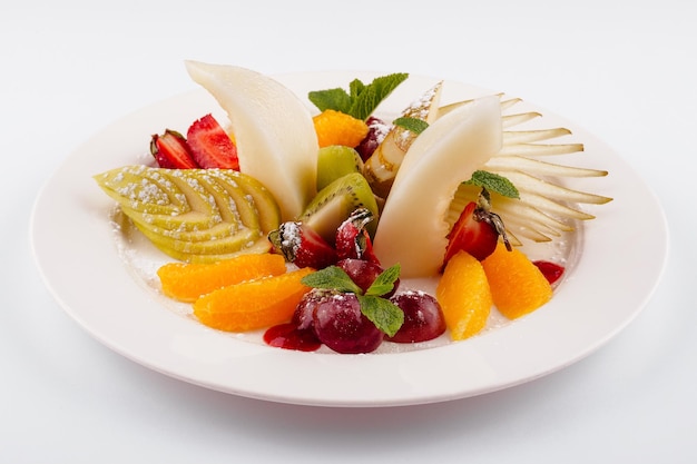 Foto ensalada de frutas frescas en un plato blanco aislado en blanco
