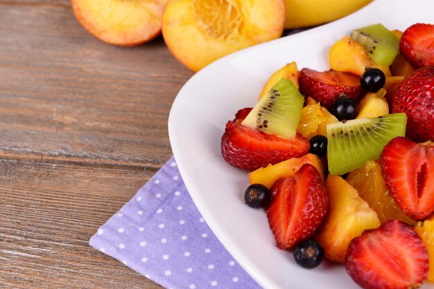 Ensalada de frutas frescas en un plato con una mesa de cerca