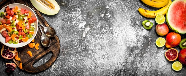 Ensalada de frutas frescas sobre fondo de piedra