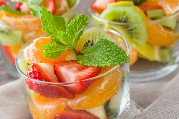 Ensalada de frutas frescas en vidrio en la mesa de madera