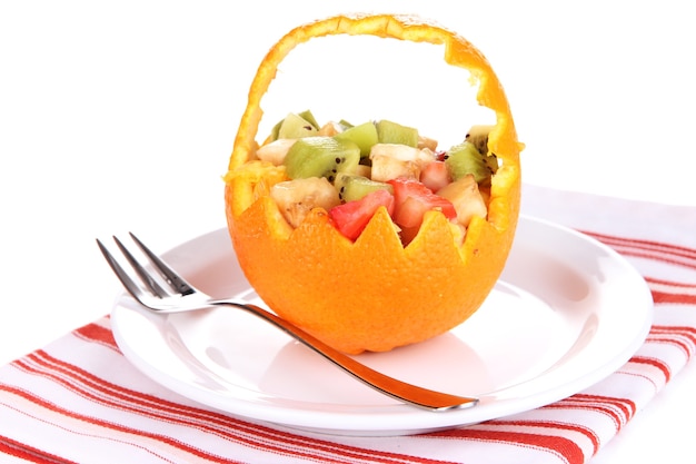 Ensalada de frutas en naranja ahuecada aislado en blanco