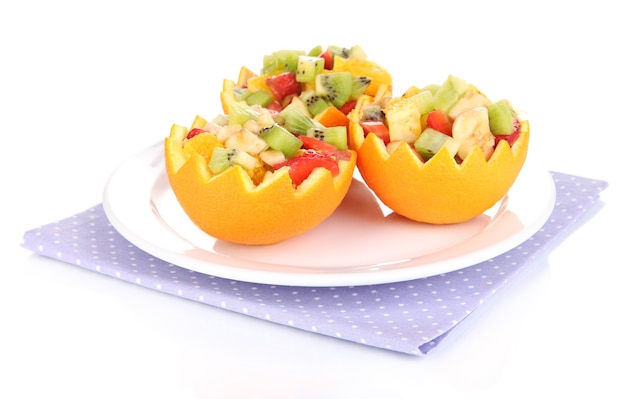 Ensalada de frutas en naranja ahuecada aislado en blanco