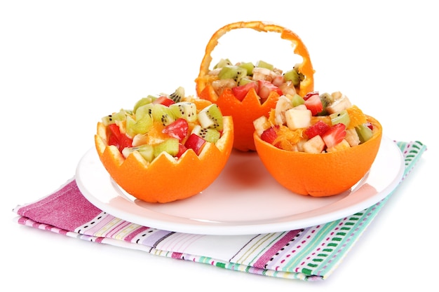 Ensalada de frutas en naranja ahuecada aislado en blanco