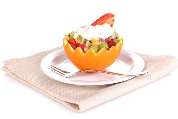 Ensalada de frutas en naranja ahuecada aislado en blanco