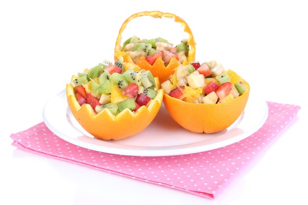 Ensalada de frutas en naranja ahuecada aislado en blanco