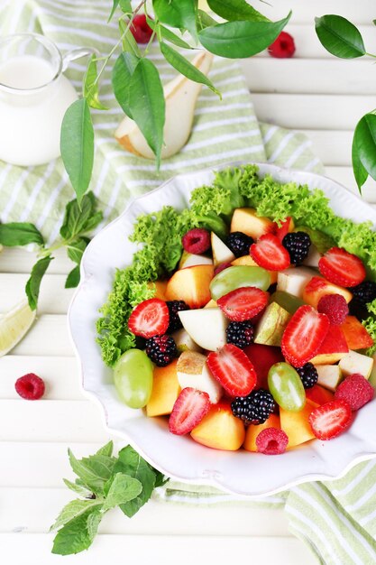 Ensalada de frutas en plato sobre mesa de madera