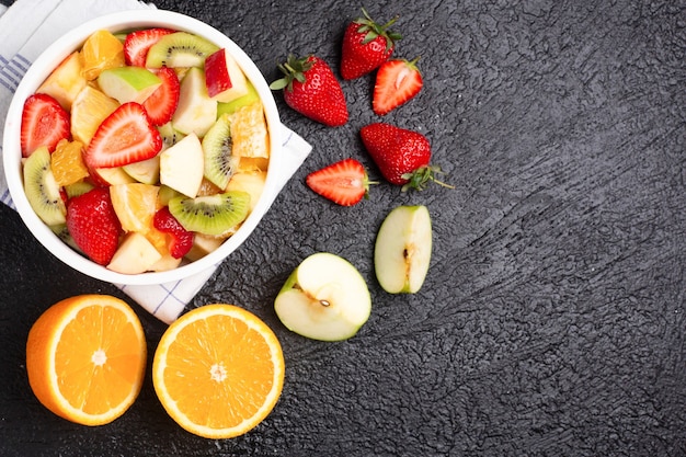 Ensalada de frutas sabrosa en la mesa negra