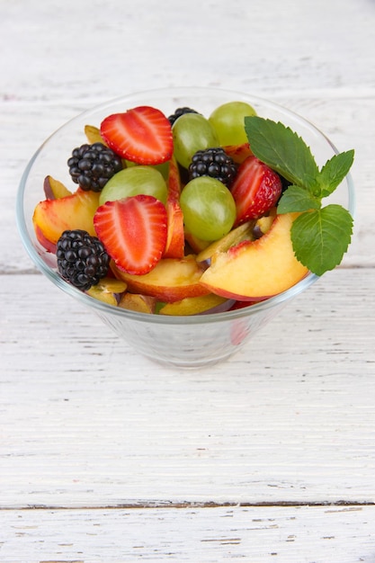 Ensalada de frutas sabrosas en la mesa de madera