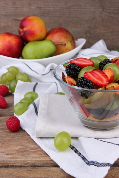 Ensalada de frutas sabrosas en la mesa de madera