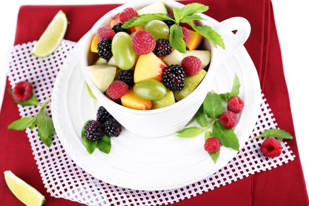 Ensalada de frutas en taza en servilleta aislado en blanco