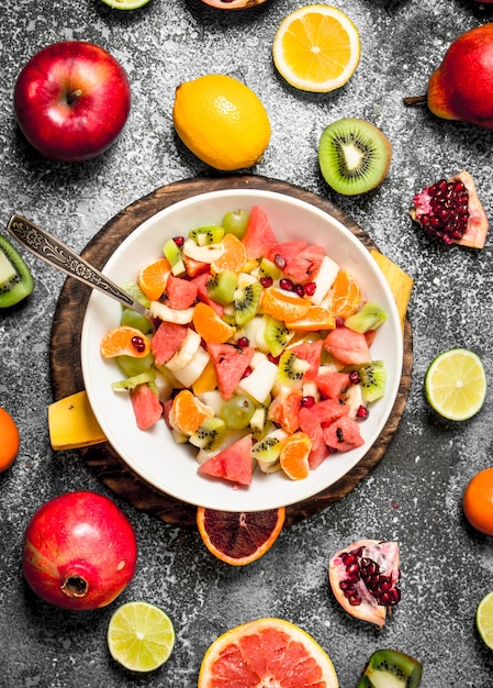 Una ensalada de frutas tropicales sobre fondo rústico