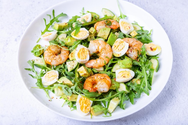 Ensalada con gambas, aguacate, pepino, huevos de codorniz y rúcula. Cocina tradicional mediterránea. Primer plano.