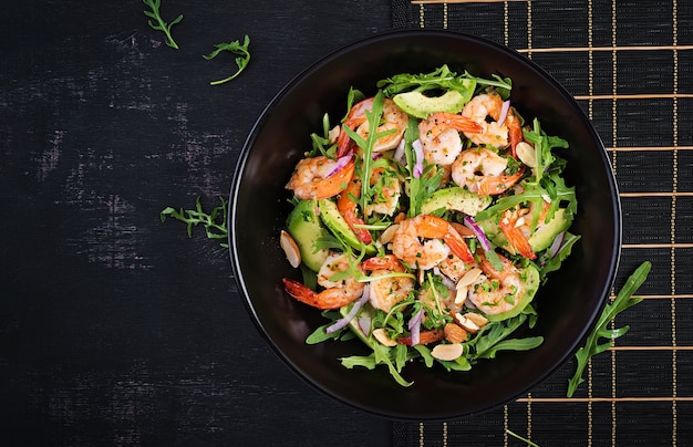 Ensalada de gambas. Ensalada de camarones, rúcula, rodaja de aguacate, cebolla morada y nueces de almendra. Concepto saludable. Vista superior, arriba