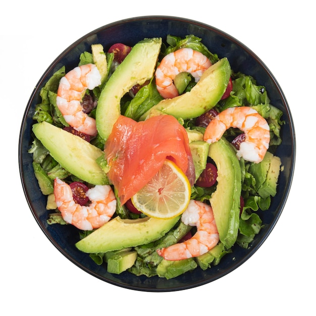 Ensalada de gambas con salmón y aguacate en un plato azul sobre un fondo blanco