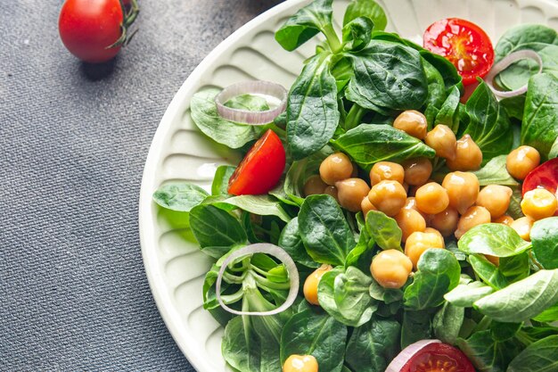 Ensalada de garbanzos, legumbres, lechuga, mache, tomate, comida fresca y saludable, comida, bocadillos, dieta en la mesa.