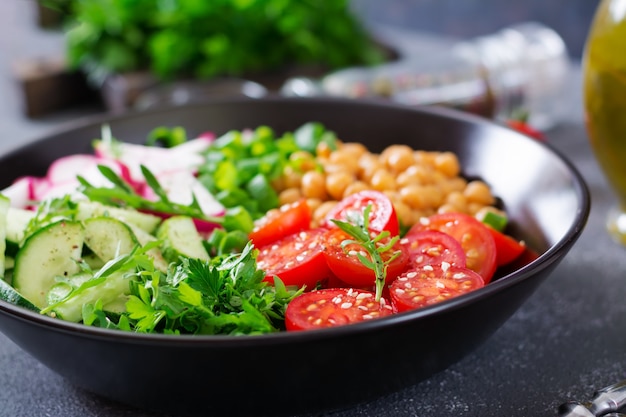 Ensalada de garbanzos, tomates, pepinos, rábanos y verduras. Comida dietética Tazón de Buda. Ensalada vegana