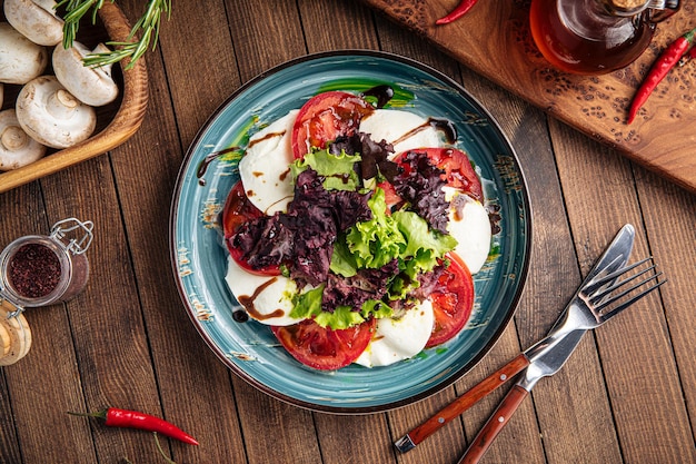 Ensalada gourmet de tomate y mozzarella caprese con ensalada de lechuga