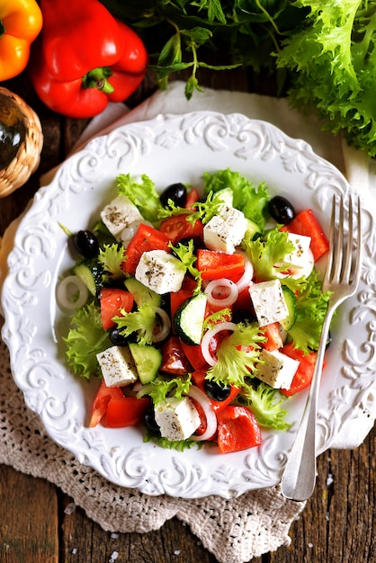 Ensalada griega clásica de tomates, pepinos, pimiento rojo, cebolla con aceitunas, orégano y queso feta.
