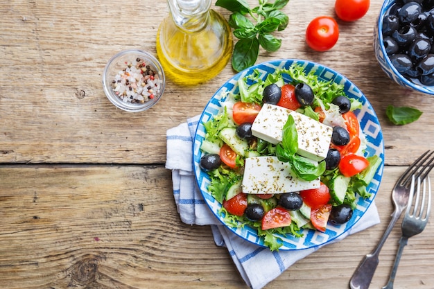 Ensalada griega fresca de pepino, tomate, pimiento dulce, cebolla morada, queso feta y aceitunas con aceite de oliva. Comida sana, vista superior