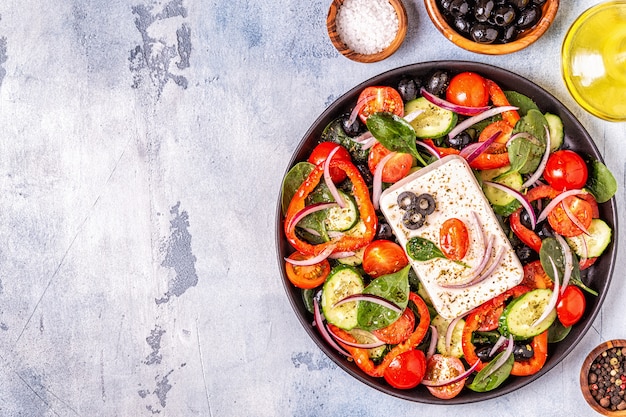 Ensalada griega de pepino fresco, tomate, pimiento dulce, espinacas, cebolla morada, queso feta y aceitunas