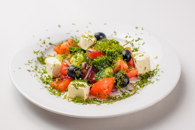 Ensalada griega en un plato sobre un blanco