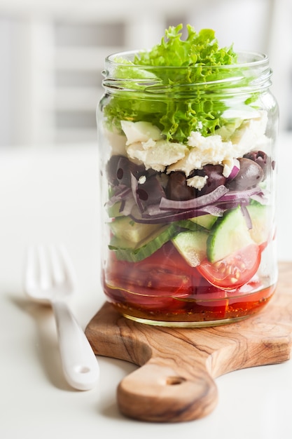 Foto ensalada griega saludable en tarro de masón. tomate aceituna feta cebolla