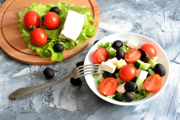 ensalada griega con tomates cherry, aceitunas negras, queso feta, pepino en un tazón con tenedor, topview