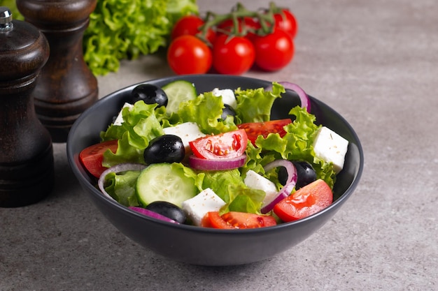 Ensalada griega con tomates frescos, pepino, aceitunas, queso feta y cebolla roja. Alimentos saludables y dietéticos