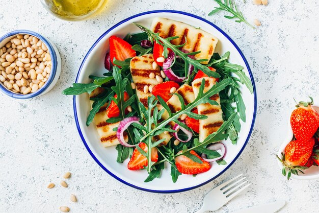 Ensalada halumi a la plancha con piñones fresas y rúcula