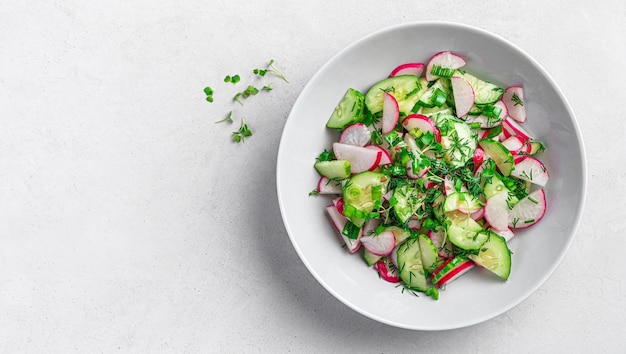 Ensalada con hierbas frescas de pepino de rábano y semillas de lino sobre un fondo gris con espacio para copiar