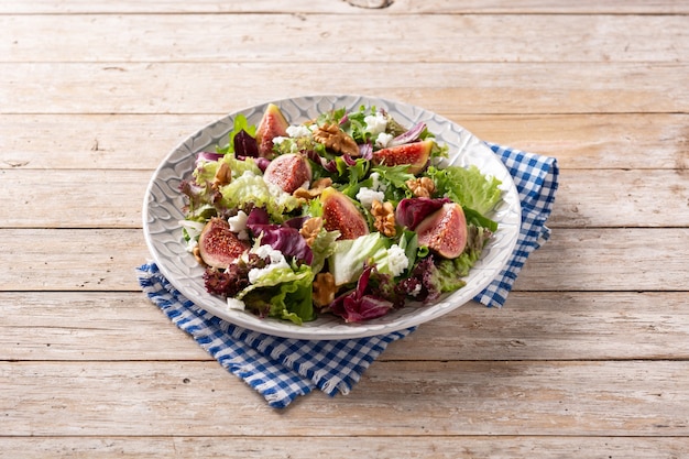 Ensalada de higos con queso y nueces sobre mesa de madera