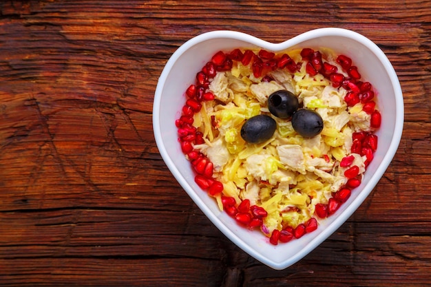 Ensalada de hojaldre con pechuga de pollo y piña con guarnición de granada y aceitunas