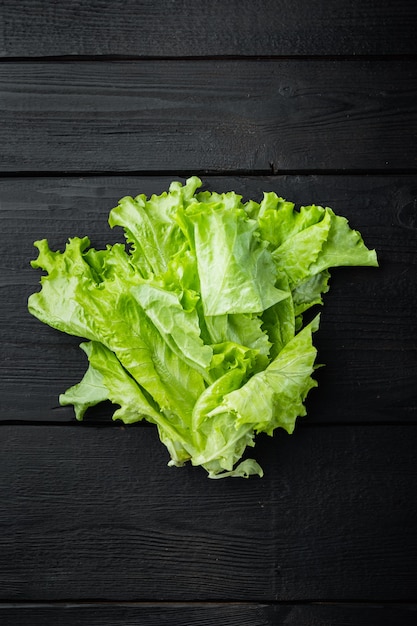 Ensalada de hojas frescas de lechuga verde, sobre mesa de madera negra