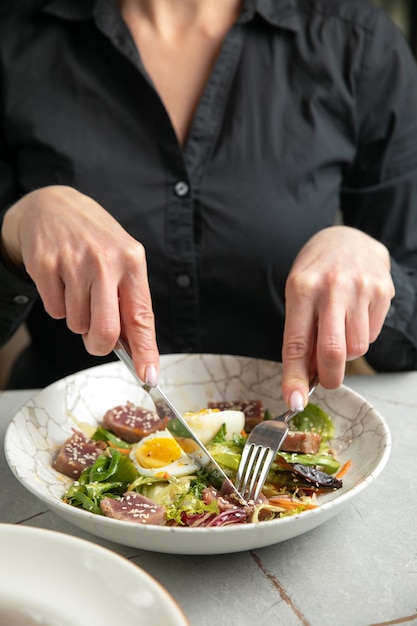 Ensalada con huevo de hierbas de lechuga de atún sobre una mesa gris