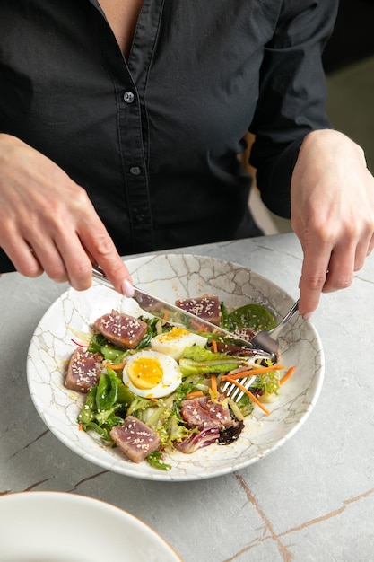 Ensalada con huevo de hierbas de lechuga de atún sobre una mesa gris