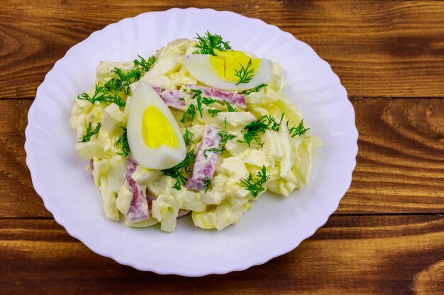 Ensalada con huevos de salchicha de cebolla de repollo chino y mayonesa sobre mesa de madera