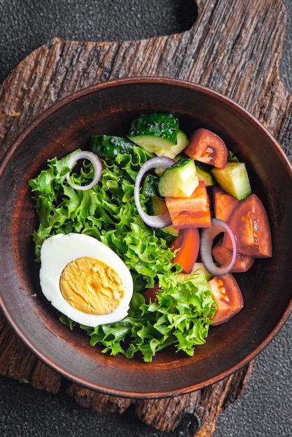Ensalada de huevos vegetales pepino tomate lechuga vegetariana comida saludable merienda dieta en la mesa