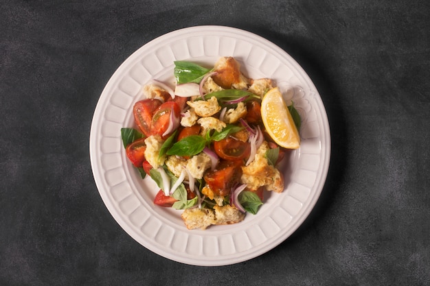 Foto ensalada italiana de aperitivo con tomate, pan y bazil