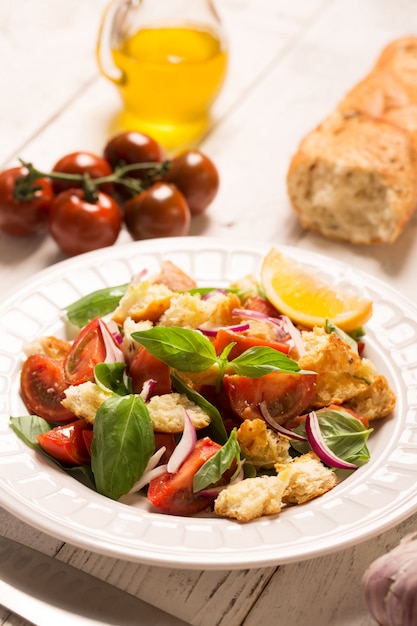 Ensalada italiana de aperitivo con tomate, pan y bazil