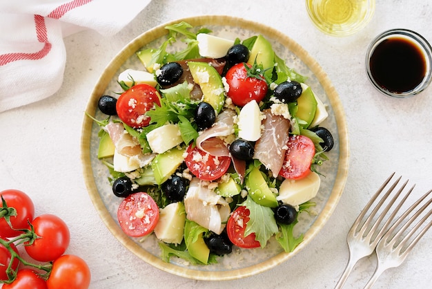 Ensalada de jamón, mozzarella, aguacate, tomates cherry, aceitunas negras y parmesano