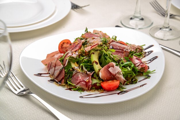 Ensalada con jamón de parma jamón, tomate y rúcula