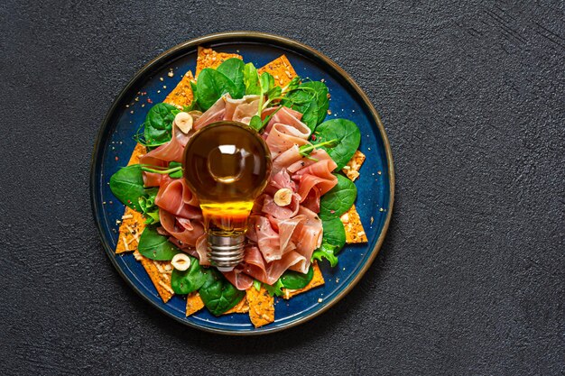 Ensalada de jamón prosciutto, espinacas y lechuga con microvegetales de nueces crujientes de pan salado