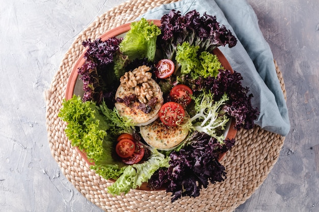 Ensalada con lechuga, cerezas, tomates, queso de cabra, nueces y especias.