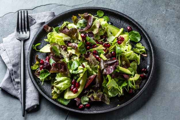 Ensalada de lechuga con granada en placa negra