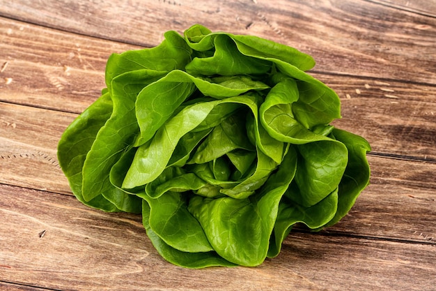 Ensalada de lechuga de mantequilla hojas verdes sobre fondo de madera