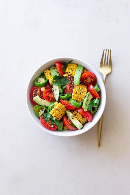 Ensalada de maíz aguacate tomate pimientos y perejil Alimentación saludable Comida vegetariana