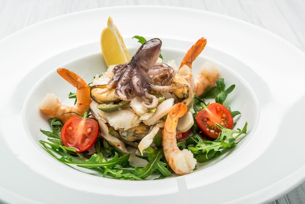 Ensalada de mariscos y vegetales con rúcula y tomates.