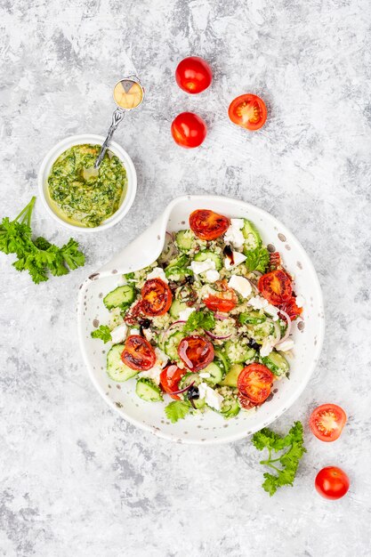 Ensalada mediterránea de cuscús con tomates cherry fritos, pepino y salsa pesto