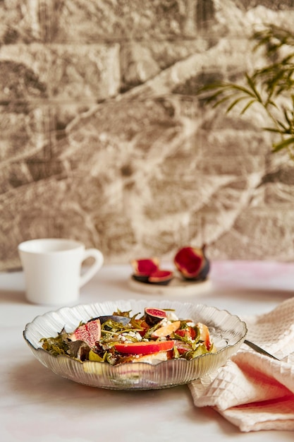 Ensalada mediterránea con higos frescos, grano de rúcula, queso rústico, batata y taza de café. Desayuno saludable. Ensalada vegana fresca.